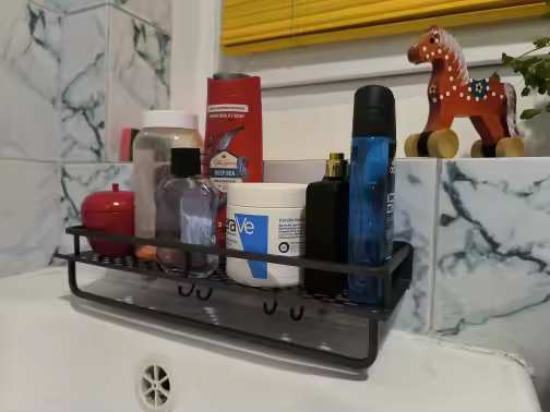 Black GripNest shelf keeping daily toiletries organised above a bath
